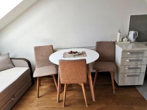 a kitchen with a table and three chairs and a table at Stan na dan M in Novi Sad