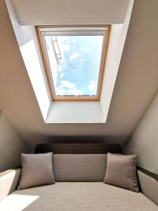 a skylight window in a room with a couch at Stan na dan M in Novi Sad