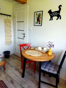 Chyrowa的住宿－Pokoje goscinne u Olguni，餐桌和墙上的黑猫