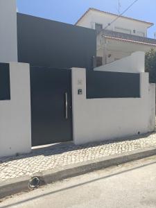 a black door on the side of a white building at Casa Saudade in Charneca
