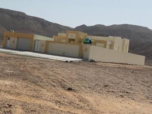 a house in the middle of a desert with a hill at شاليه درة رأس الجنز Dorrat Ras Al Jinz Chalet in Junayz al Janūbī