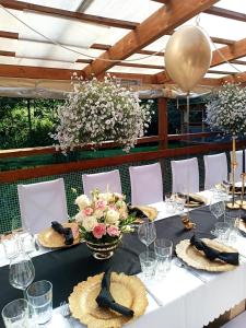 a table with a black table cloth and flowers on it at Restauracja i Noclegi Izba Rybacka w Krainie Wygasłych Wulkanów in Podgórki