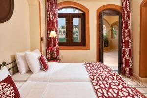 a bedroom with a bed with red curtains and a window at Dawar El Omda (Adults Only) in Hurghada