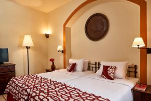 a hotel room with two beds and a tv at Dawar El Omda (Adults Only) in Hurghada