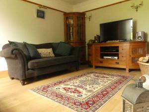 a living room with a couch and a flat screen tv at Silverstripe in Turriff