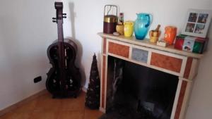 sala de estar con chimenea y guitarra en Domus giuseppe, en Guardiabruna