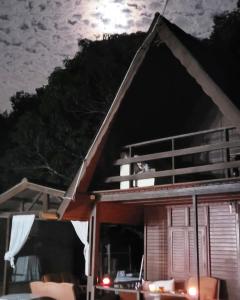 una pequeña casa con porche por la noche en Sitio Arco Iris da Lia, en São Roque