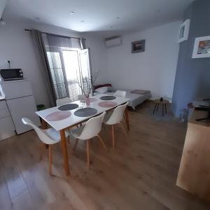 a dining room with a white table and chairs at Apartments Filipovic in Biograd na Moru