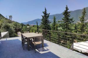 a patio with a table and chairs on a balcony at Luxury Villa Serani with Panoramic View in Vasiliki
