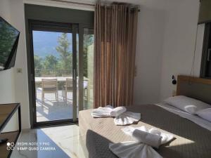 a bedroom with a bed and a view of a patio at Luxury Villa Serani with Panoramic View in Vasiliki
