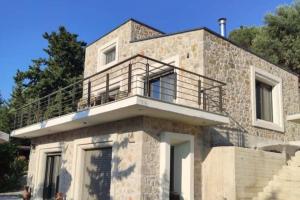 a building with a balcony on top of it at Luxury Villa Serani with Panoramic View in Vasiliki