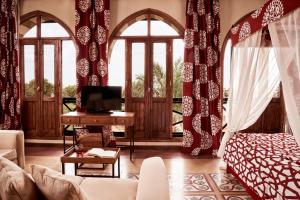 ein Wohnzimmer mit einem Sofa, einem Schreibtisch und Fenstern in der Unterkunft Dawar El Omda (Adults Only) in Hurghada