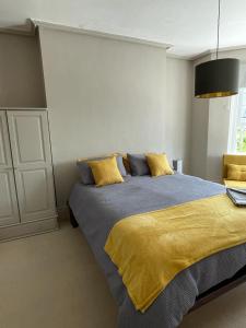 a bedroom with a large bed with a yellow blanket at Northampton House in Llanwrtyd Wells