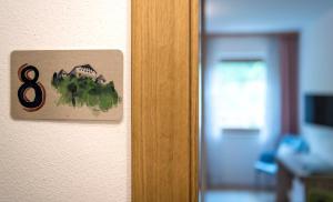 een bord op een deur met nummer acht erop bij Niederhof life in Lana