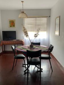 ein Esszimmer mit einem Tisch, Stühlen und einem Klavier in der Unterkunft Tinku-Huasi Apart in San Salvador de Jujuy + 8 Fotos