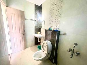 y baño con aseo y lavamanos. en 3BHK Luxurious Apartment (AC/TV/Kitchen), en Mangalore