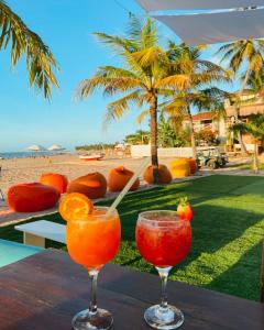 two cocktails on a table next to the beach at Pousada Casa Canto das Águas in Icaraí