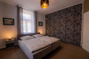 a bedroom with a bed and a wall with a window at Villa Waldlust - 5 Sterne - 2 Schlafzimmer in Kurort Oybin