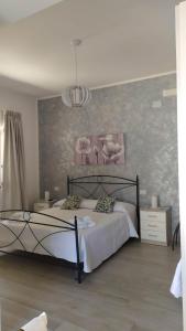een slaapkamer met een bed en een schilderij aan de muur bij Affittacamere Sole e Luna in Vatolla