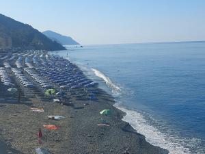 a beach with umbrellas and people on the beach at Casa Margherita in Deiva Marina