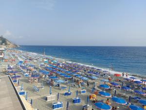 uma praia cheia de guarda-sóis azuis e azuis em Casa Margherita em Deiva Marina