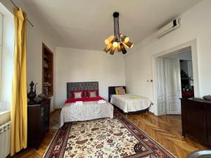 a bedroom with two beds and a chandelier at Historijski luksuz u Starom Gradu, Garage Parking in Sarajevo
