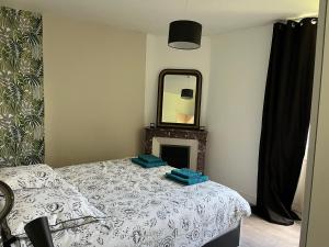 Schlafzimmer mit einem Bett und einem Spiegel in der Unterkunft L’Annexe in Chantelle