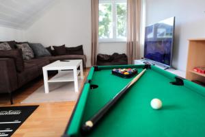 a living room with a green pool table at Goldhouse - Sauna, Whirlpool, Switch, Darts & mehr in Andernach