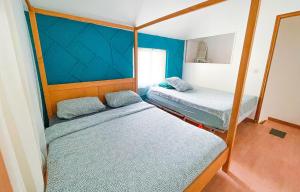 2 Betten in einem Zimmer mit blauen Wänden in der Unterkunft MISSYT DUPLEX COLOMBES PROCHE PARIS ET LA DÉFENSE in Colombes