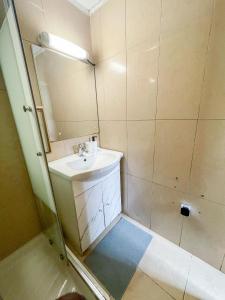 ein kleines Bad mit einem Waschbecken und einer Dusche in der Unterkunft MISSYT DUPLEX COLOMBES PROCHE PARIS ET LA DÉFENSE in Colombes