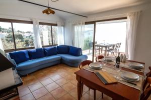 a living room with a blue couch and a table at La Caseta de Cadaqués in Cadaqués