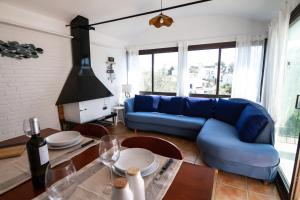 a living room with a blue couch and a table at La Caseta de Cadaqués in Cadaqués