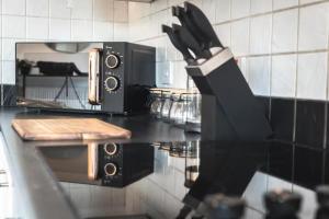 a kitchen counter with a knife sticking out of a microwave at Chic 2-Bed Apartment in Southampton with Parking in Southampton