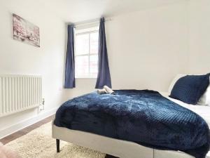 a bedroom with a bed with a blue blanket at Chic 2-Bed Apartment in Southampton with Parking in Southampton