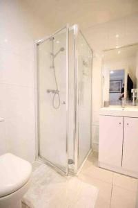 ein weißes Bad mit einer Dusche und einem WC in der Unterkunft Wonderful apartment in Earl’s Court in London