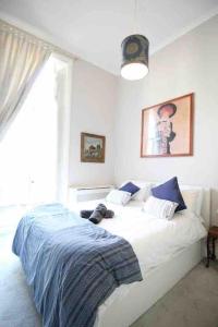 ein Schlafzimmer mit einem Bett, auf dem ein Hund liegt in der Unterkunft Wonderful apartment in Earl’s Court in London