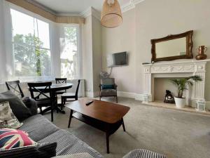 ein Wohnzimmer mit einem Sofa und einem Tisch in der Unterkunft Wonderful apartment in Earl’s Court in London