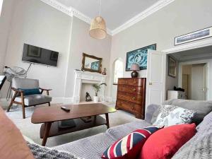 ein Wohnzimmer mit einem Sofa und einem Tisch in der Unterkunft Wonderful apartment in Earl’s Court in London