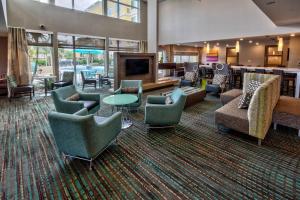 a lobby with couches and chairs and a television at Residence Inn Fort Lauderdale Pompano Beach Central in Pompano Beach