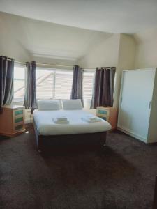 een slaapkamer met een groot bed en een groot raam bij Poachers Pocket Seaview in Bacton