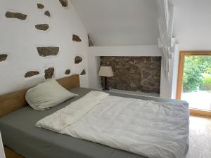 a bedroom with a bed with rocks on the wall at Cancale Chapelle du Verger in Cancale