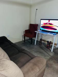 a living room with a couch and a table with a laptop at Casa camping san jerónimo in San Vicente de Cañete