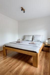 a bed sitting on a wooden floor in a room at Apartmány Slavíkov - Country Suite in Horní Radechová