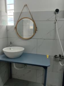 a bathroom with a sink and a mirror at NHÀ KHÁCH KEN in Cà Mau