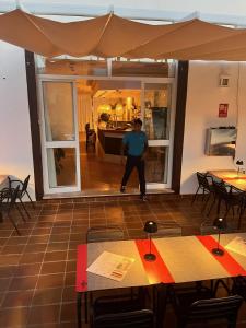 un hombre parado en medio de una habitación con mesas en Nuramar Resort & Villas, en Cala'n Bosch