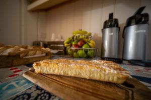 un pastel en una tabla de cortar en una mesa con un tazón de fruta en Surfside Inn Chatham, en Chatham