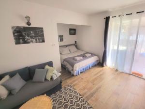 ein Wohnzimmer mit einem Sofa und einem Bett in der Unterkunft Villa-nova avec spa à 5 minutes des remparts. in Avignon