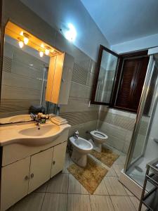 a bathroom with a sink and a toilet and a mirror at La Palma apartment in Vigevano