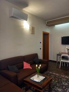 sala de estar con sofá marrón y mesa en La Palma apartment, en Vigevano