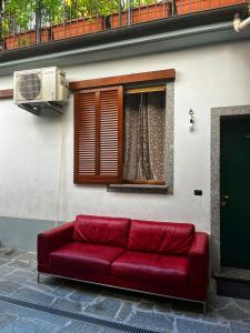 un divano rosso seduto di fronte a una finestra di La Palma apartment a Vigevano